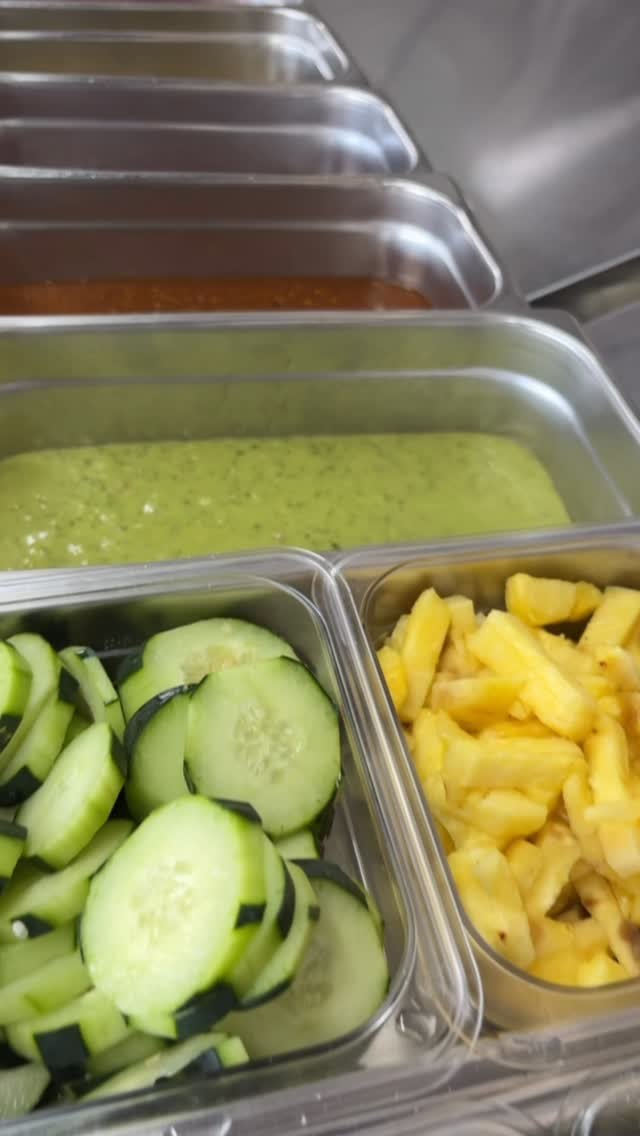 Their salsa bar: a green salsa and a red one, sliced cucumber and pineapple